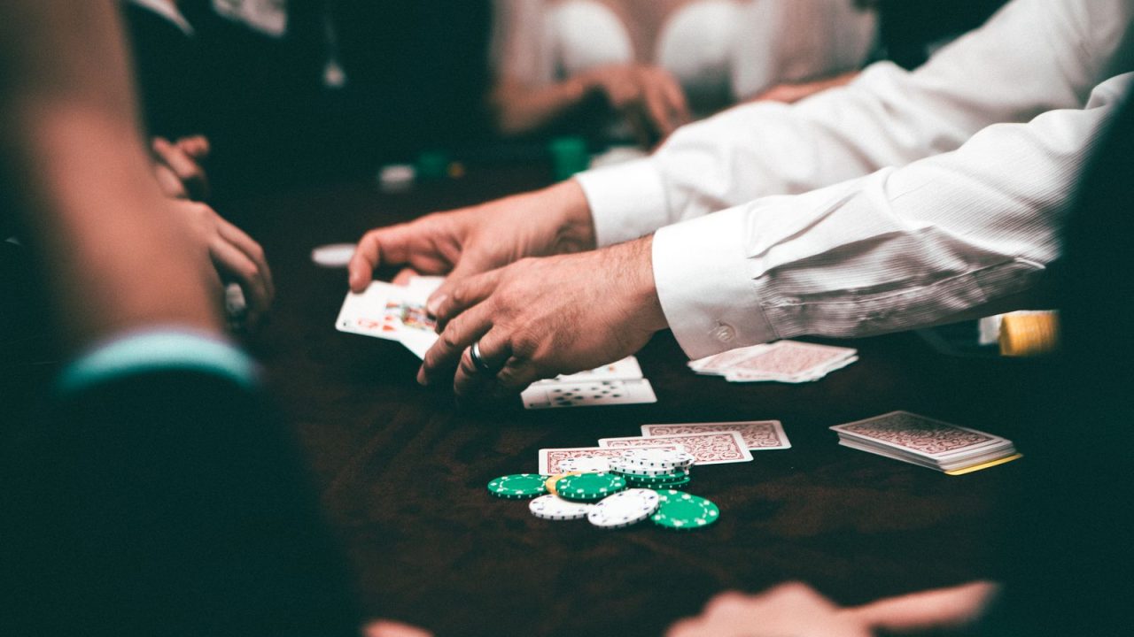 An intense poker game featuring players and poker chips on the table in an indoor setting.